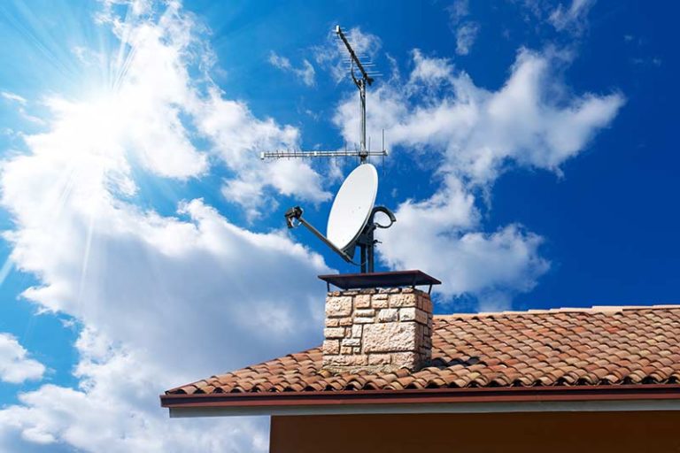 tv-satelite-against-blue-sky-on-roof-of-house